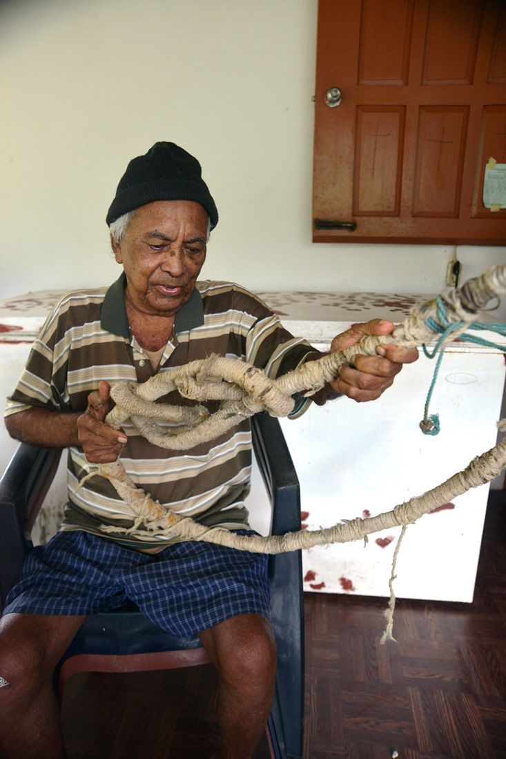 Eugene Metoo holding the device he used to climb the coconut trees.jpg